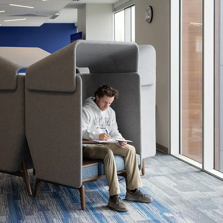 A student with curly hair, wearing a white 