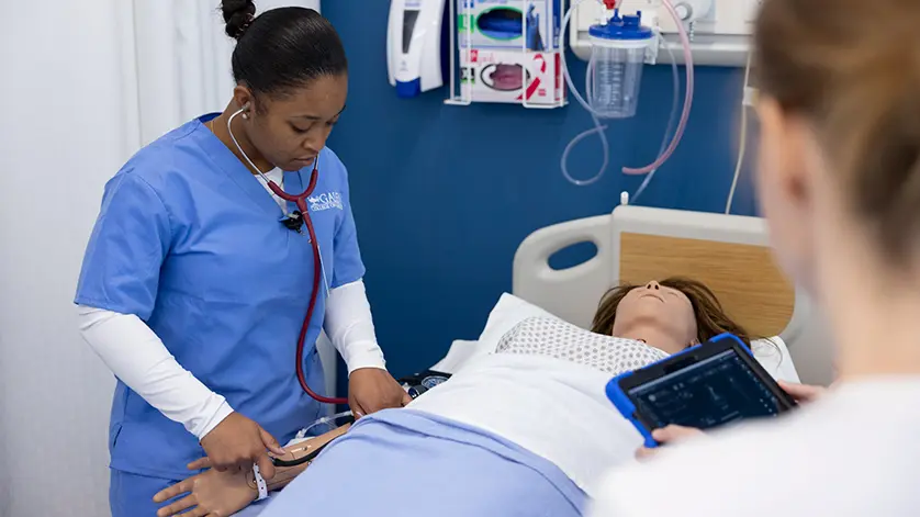 nursing student with stethoscope checking a patient in the simulation lab at Galen